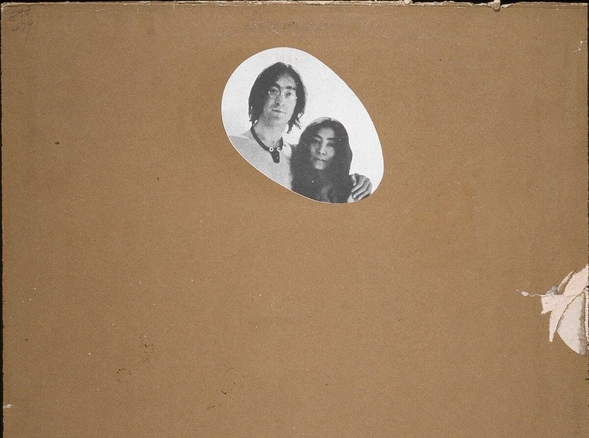 John Lennon and Yoko Ono's heads are visible in a small circle. The rest of the 'Two Virgins' album is covered by brown paper.