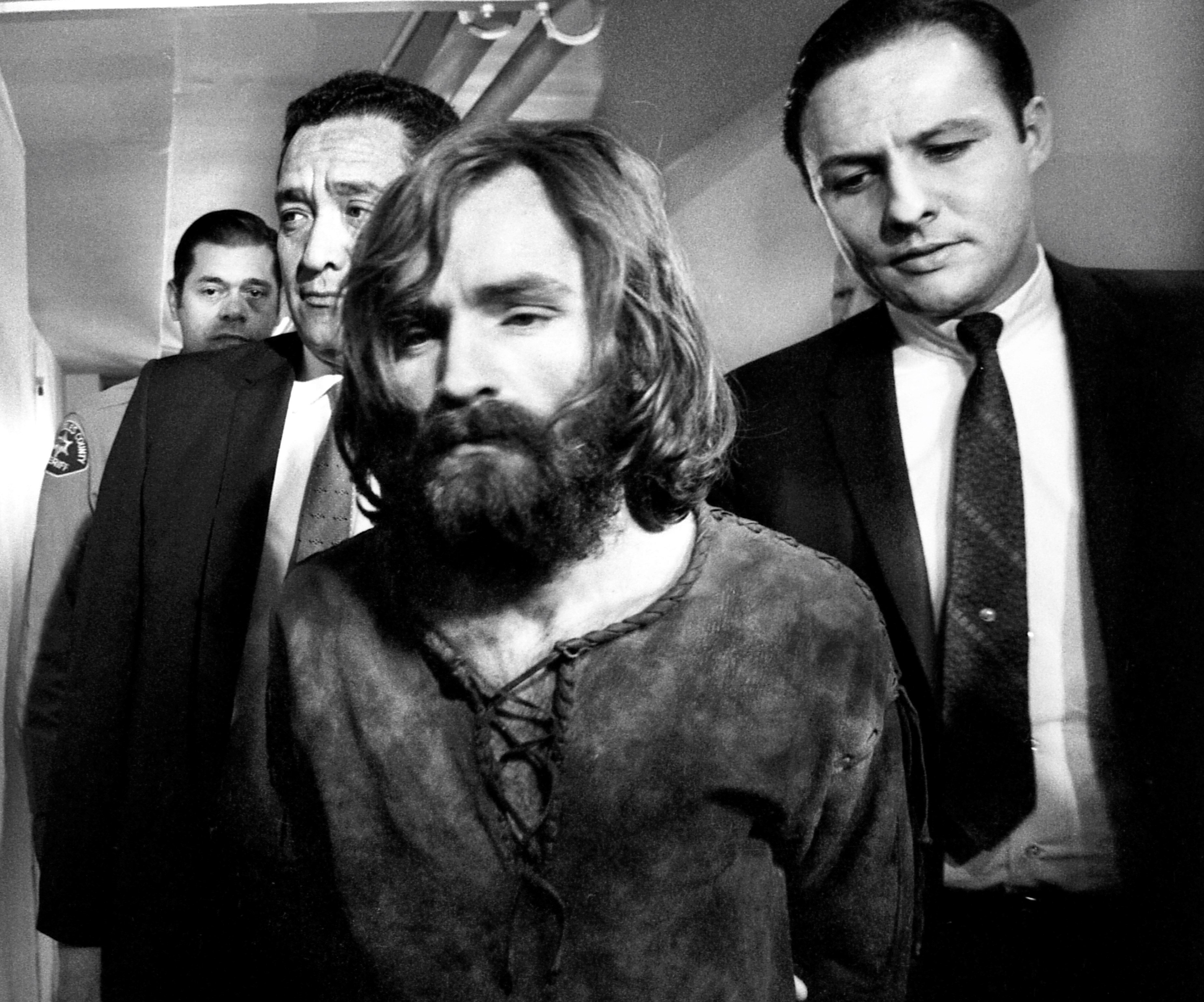Charles Manson next to three men