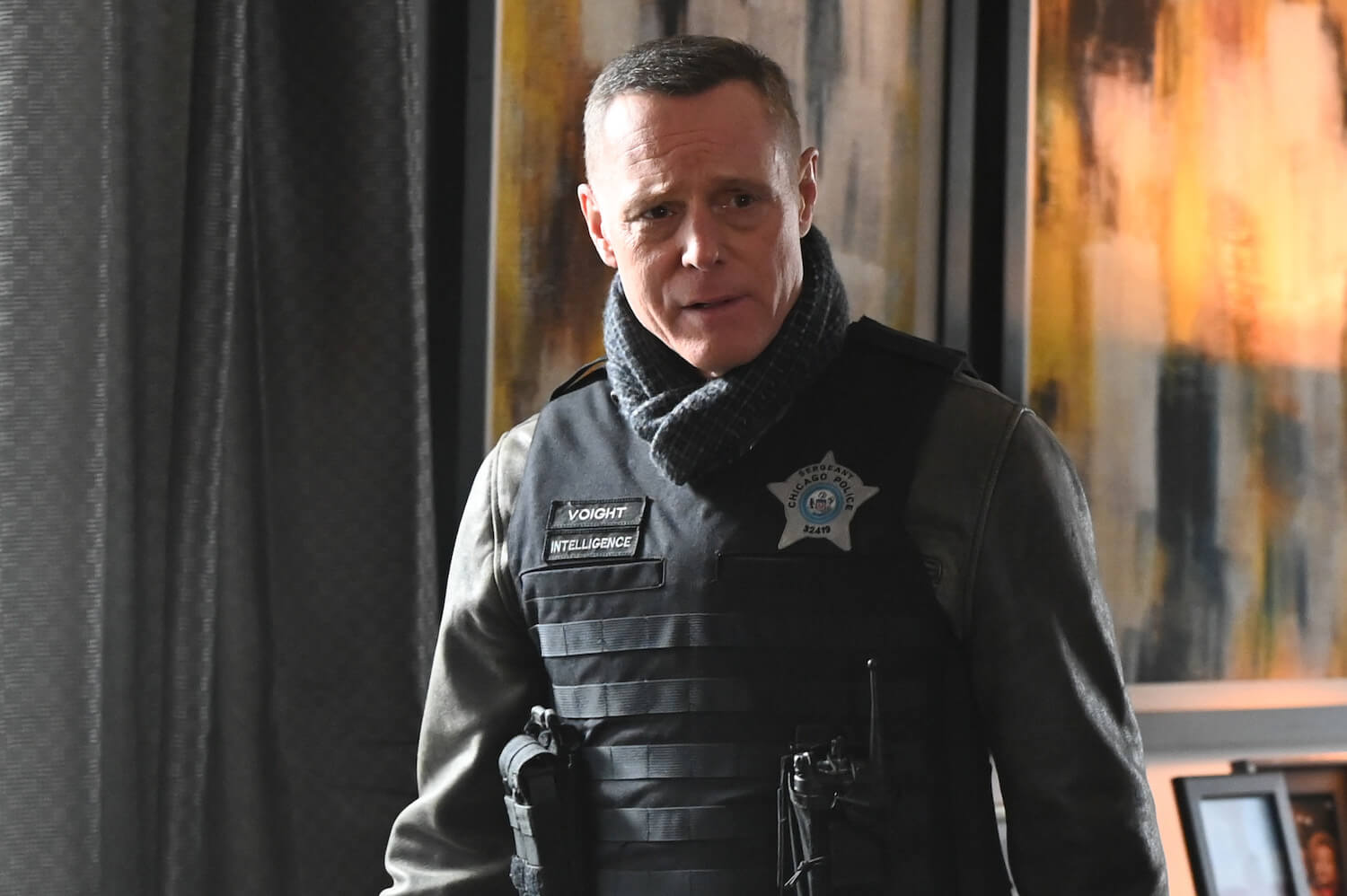 Hank Voight from 'Chicago P.D.' Season 11 standing in a house in police gear