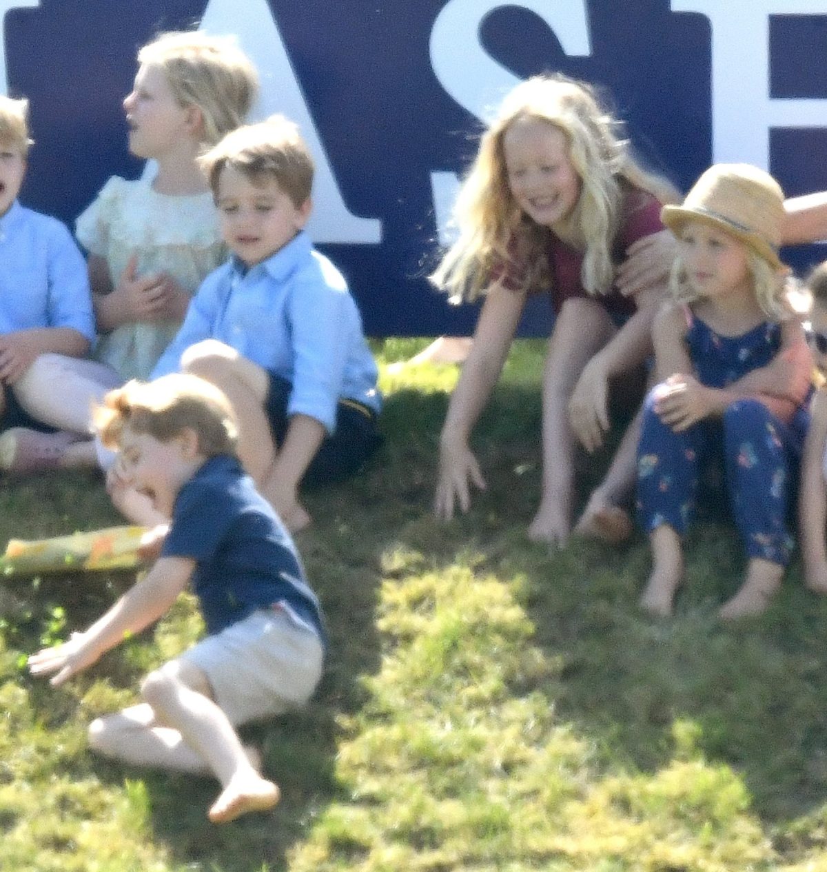 Savannah Phillips pushes Prince George down a hill during the Maserati Royal Charity Polo