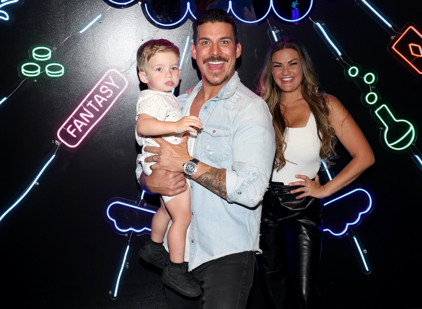 Jax Taylor holds son Cruz and wife Brittany Cartwright stands next to him