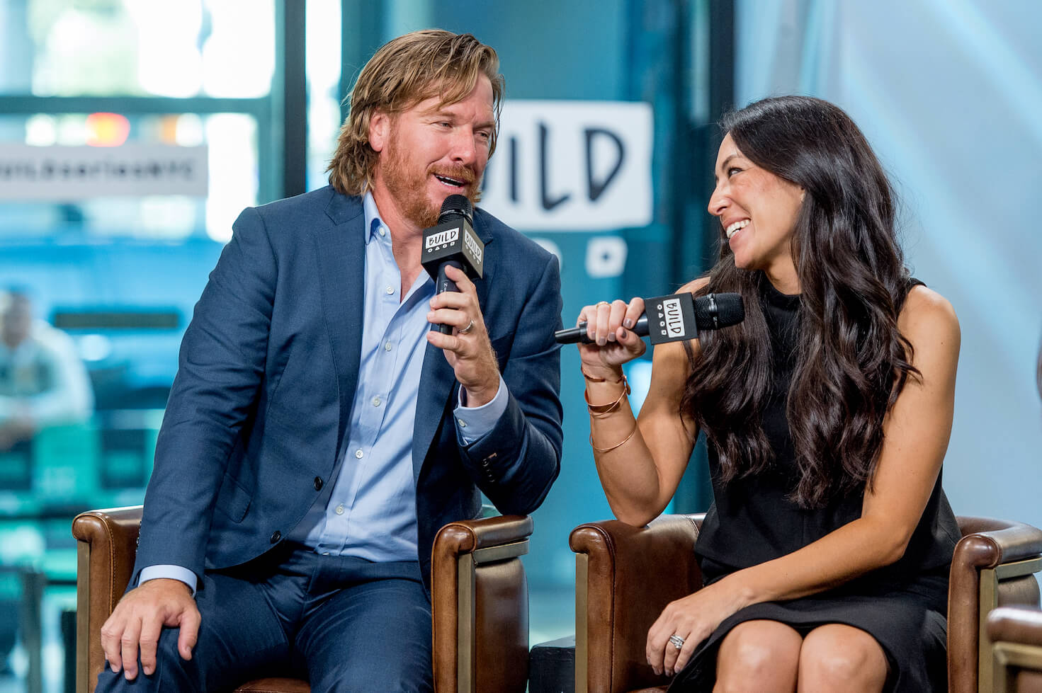 Chip and Joanna Gaines, the owners of Hotel 1928, speaking into microphones during an interview