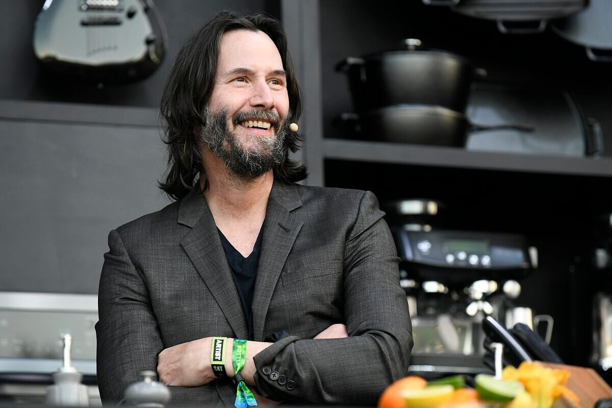 Keanu Reeves smiling while he attends a a culinary demonstration during the 2023 BottleRock Napa Valley festival.