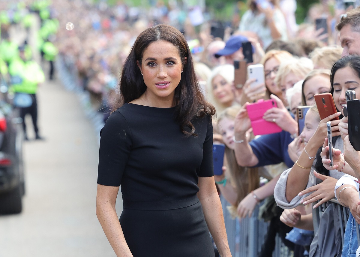 Meghan Markle meets members of the public on the long Walk at Windsor Castle after viewing flowers and tributes to HM Queen Elizabeth II