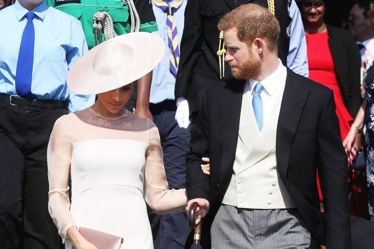 Meghan Markle, who copied Kate Middleton's 'barrier' gesture with a clutch bag in 2018, walks with Prince Harry