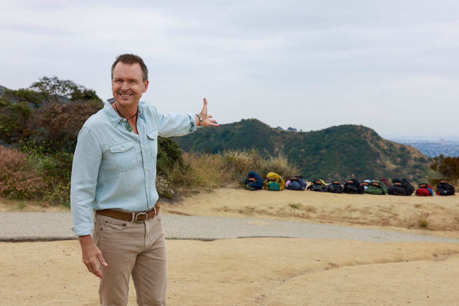 Phil Keoghan with his arm outstretched and smiling in 'The Amazing Race' Season 35