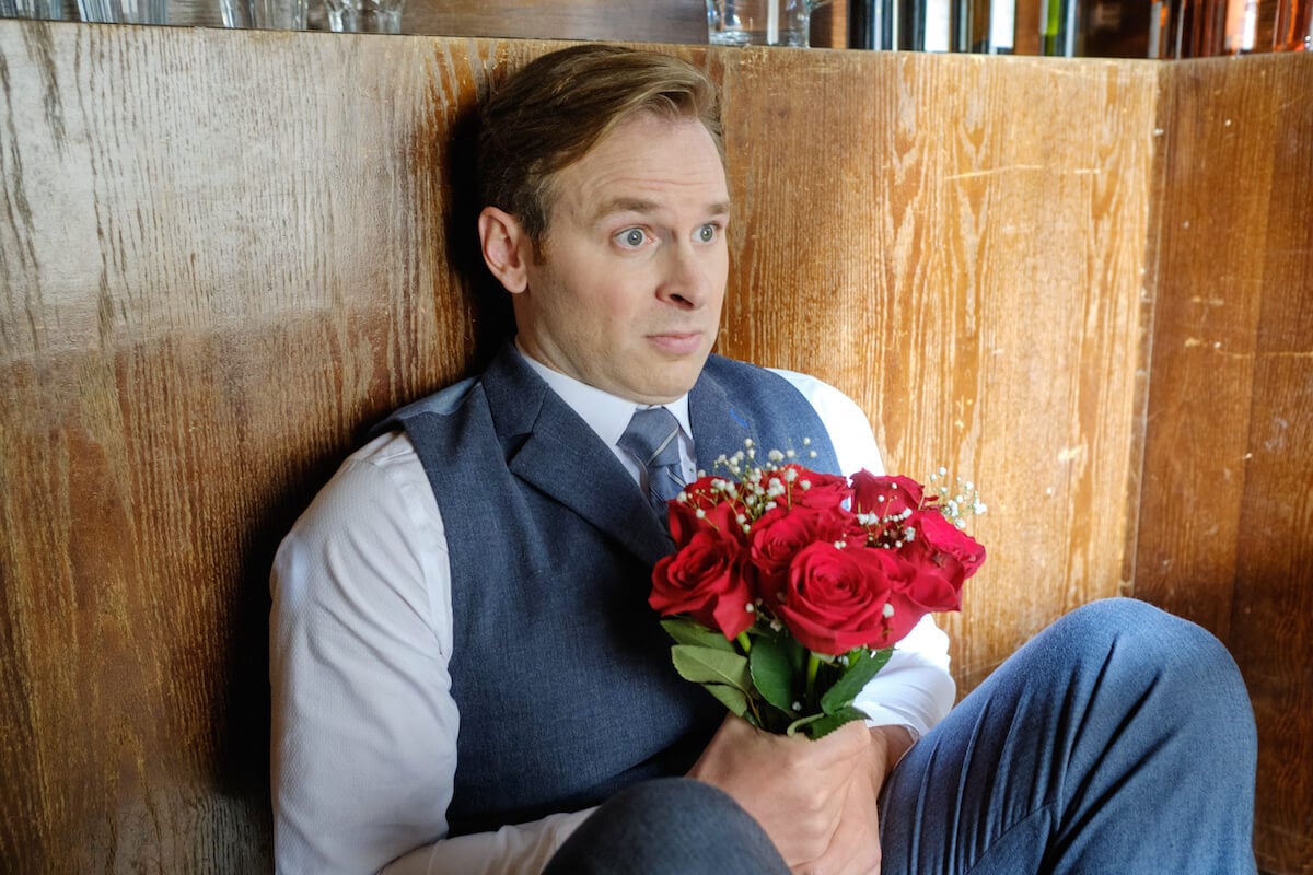 Ben Rosenbaum holding a bouquet of roses in 'When Calls the Heart'