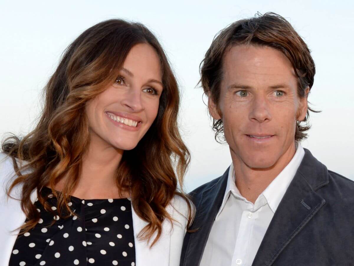 Julia Roberts wears a polka dotted black shirt and white jacket and her husband Danny Moder wears a white button down and black jacket.