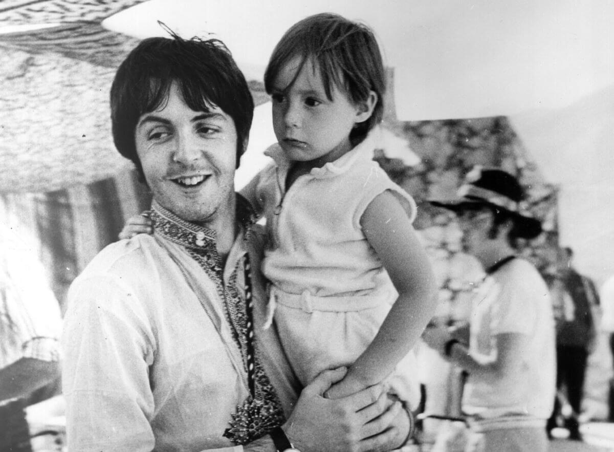 A black and white picture of Paul McCartney holding a young Julian Lennon.