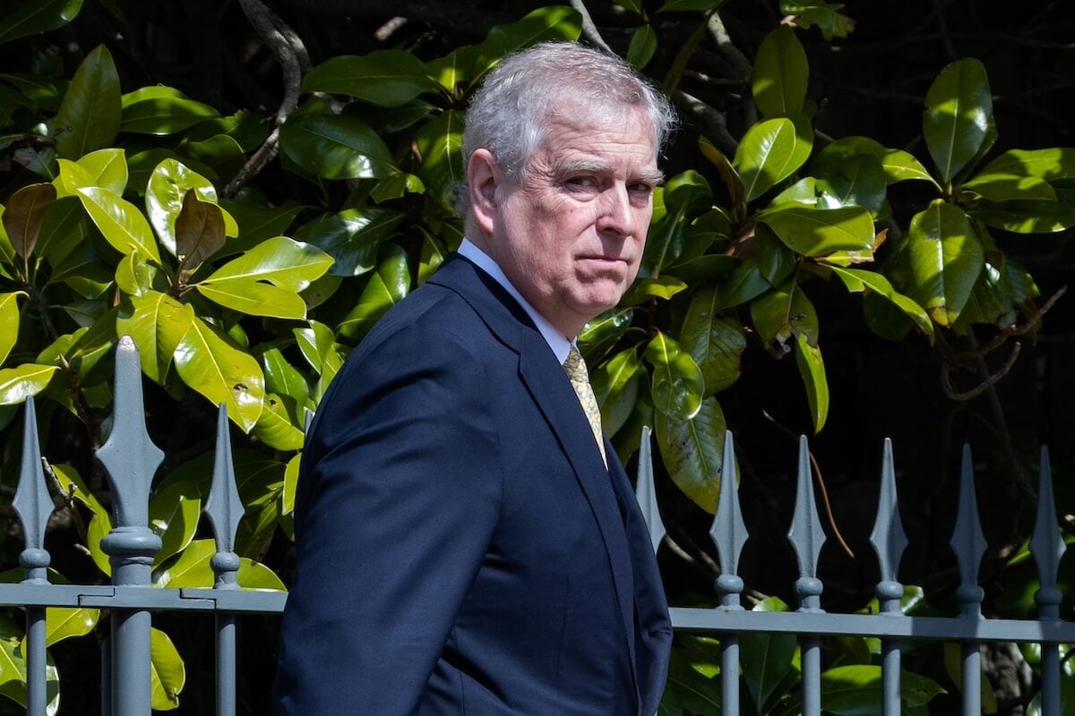Prince Andrew wearing a suit and looking over his shoulder