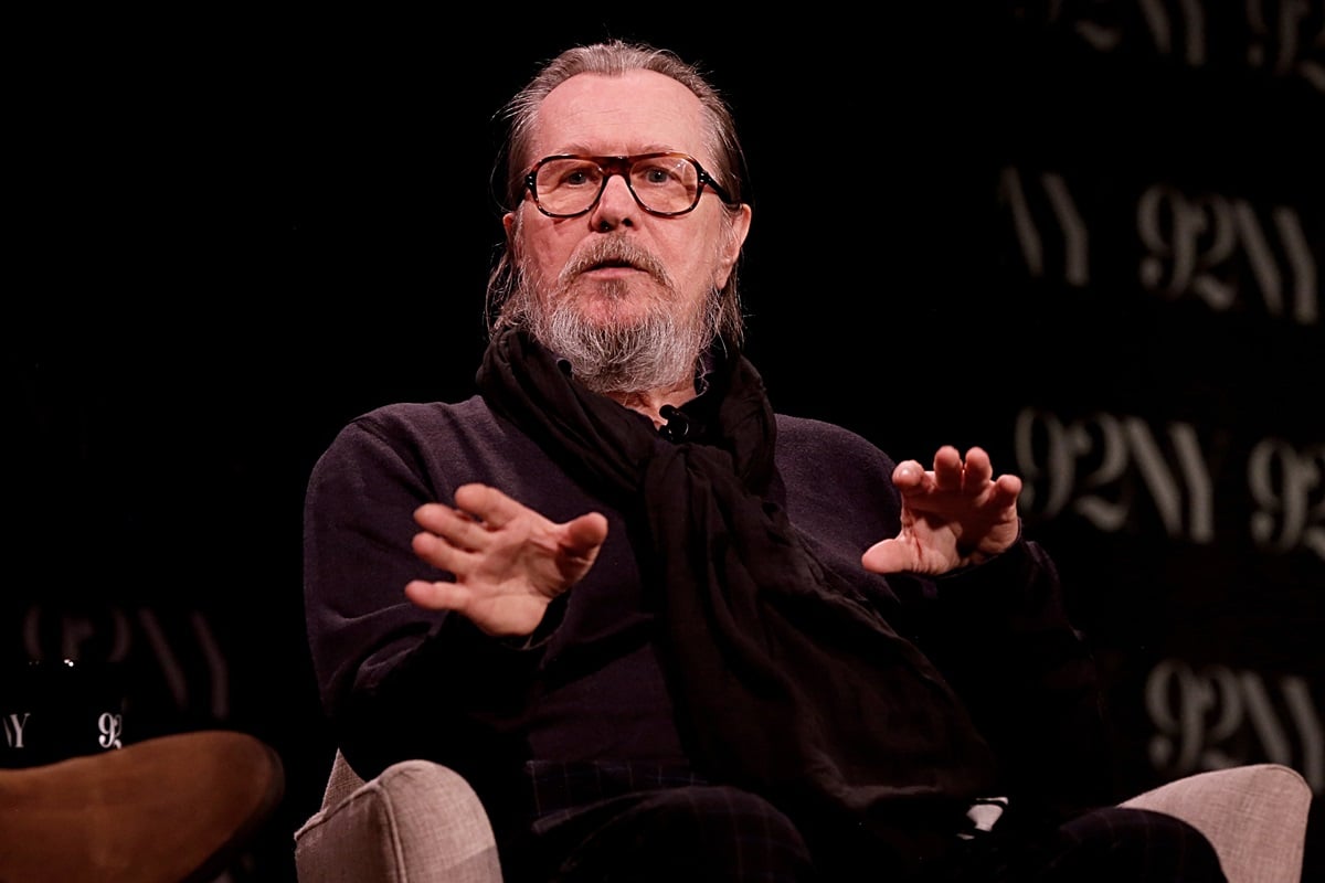 Gary Oldman sitting down wearing a black outfit at the conversation about Apple TV+'s "Slow Horses" with Josh Horowitz.