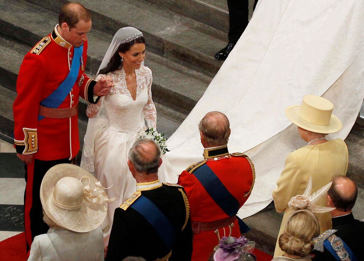 https://www.cheatsheet.com/wp-content/uploads/2023/12/Prince-William-holds-Kate-Middletons-hand-as-they-walk-down-the-aisle-and-greet-Queen-Elizabeth-II-1.jpg