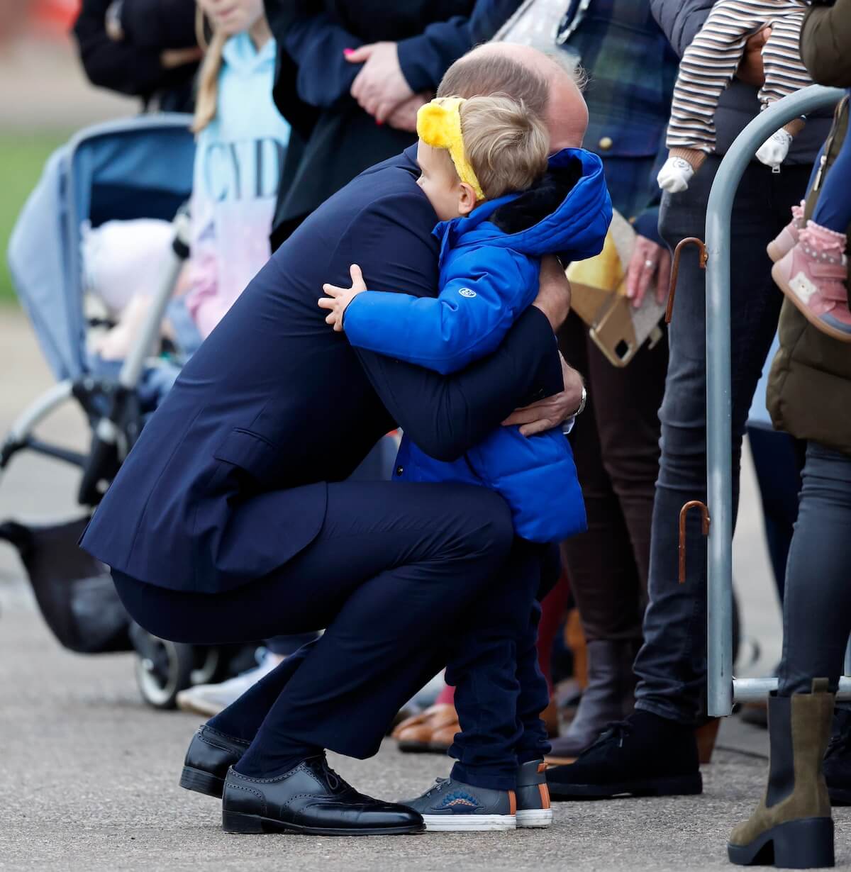 Prince William hugs a child while on a royal walkabout