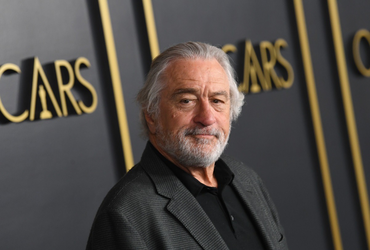 Robert De Niro posing in a suit at the Oscars.