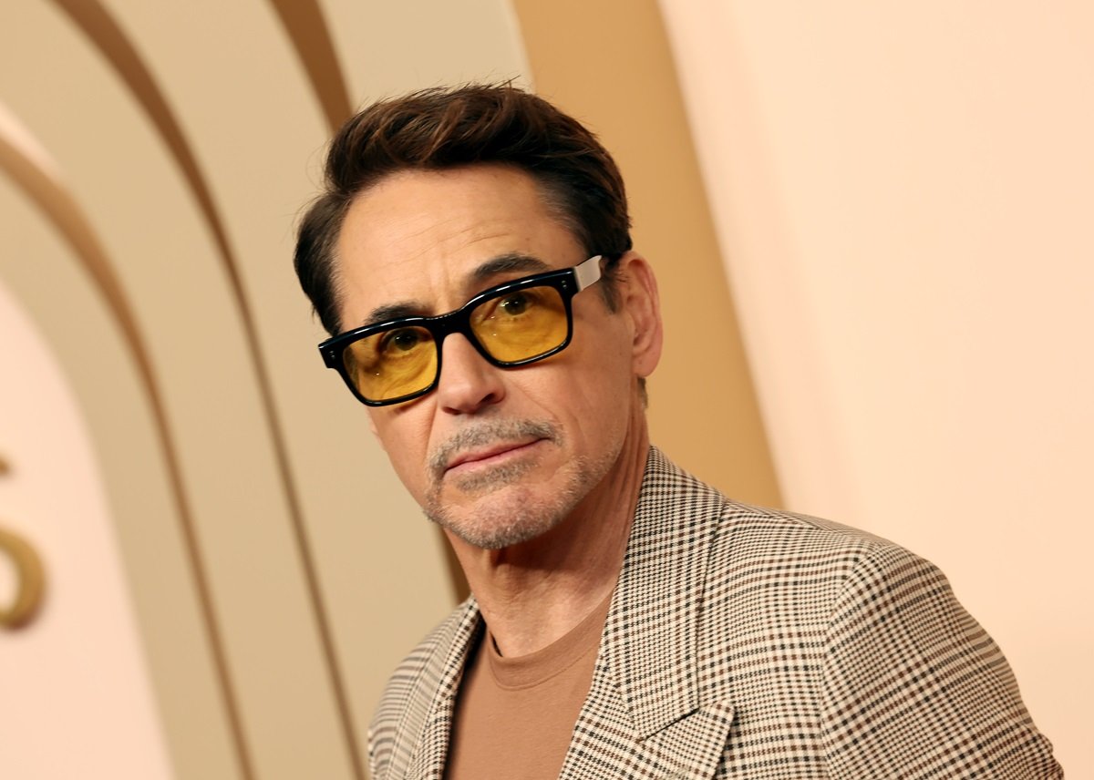 Robert Downey Jr. posing in a tan suit at the Oscars.