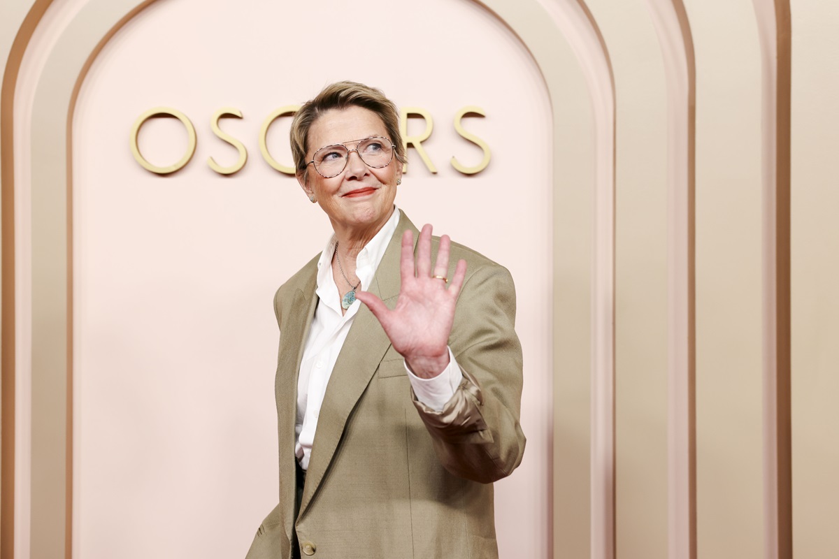 Annete Bening posing in a tan suit at Oscars luncheon.