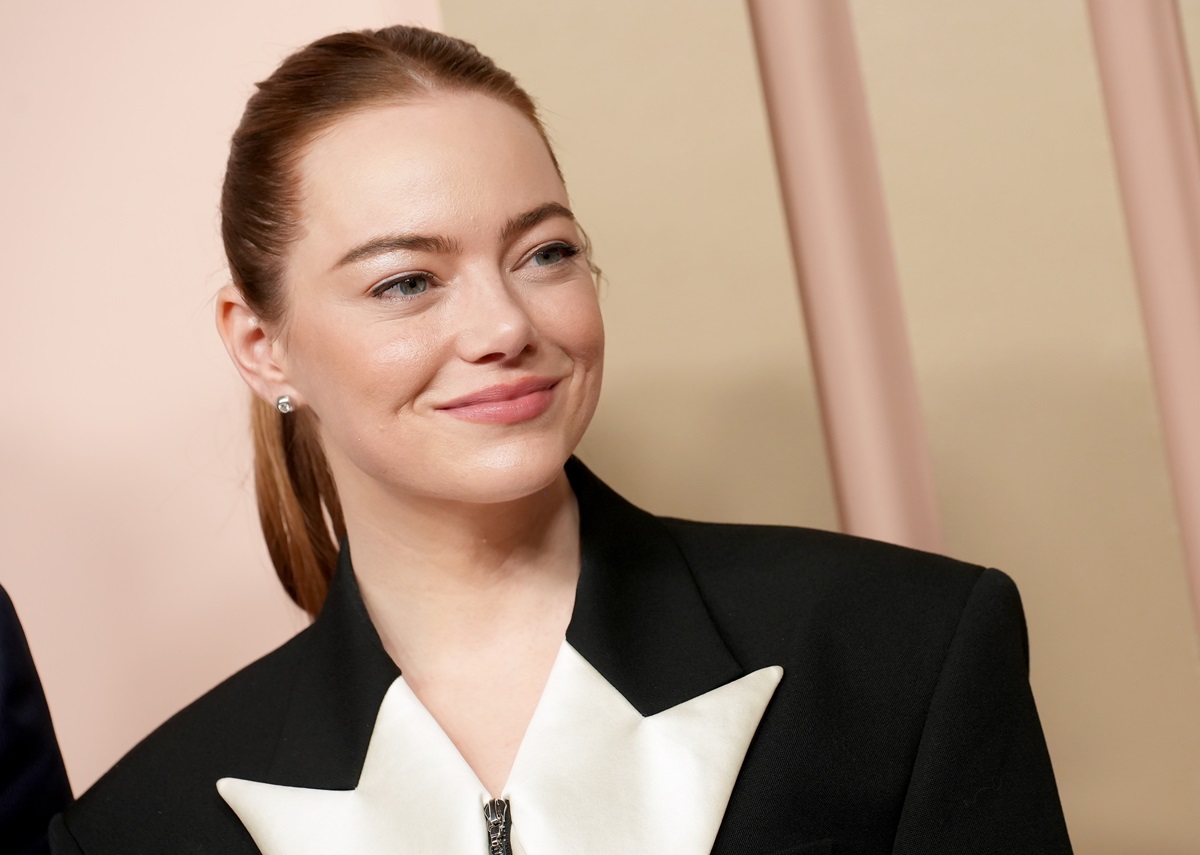 Emma Stone posing in a black and white suit.