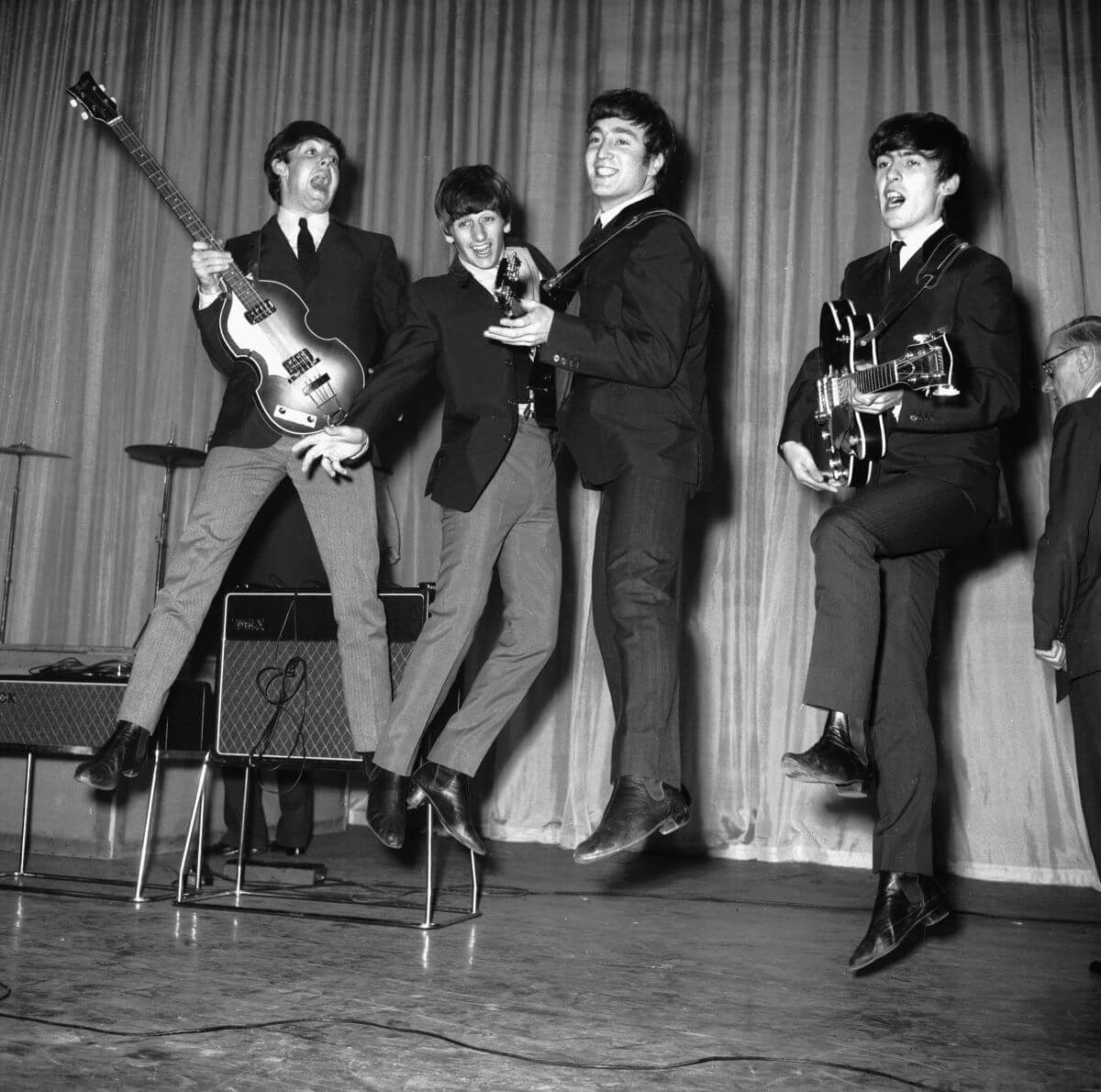 A black and white picture of Paul McCartney, Ringo Starr, John Lennon, and George Harrison of The Beatles jumping in the air.