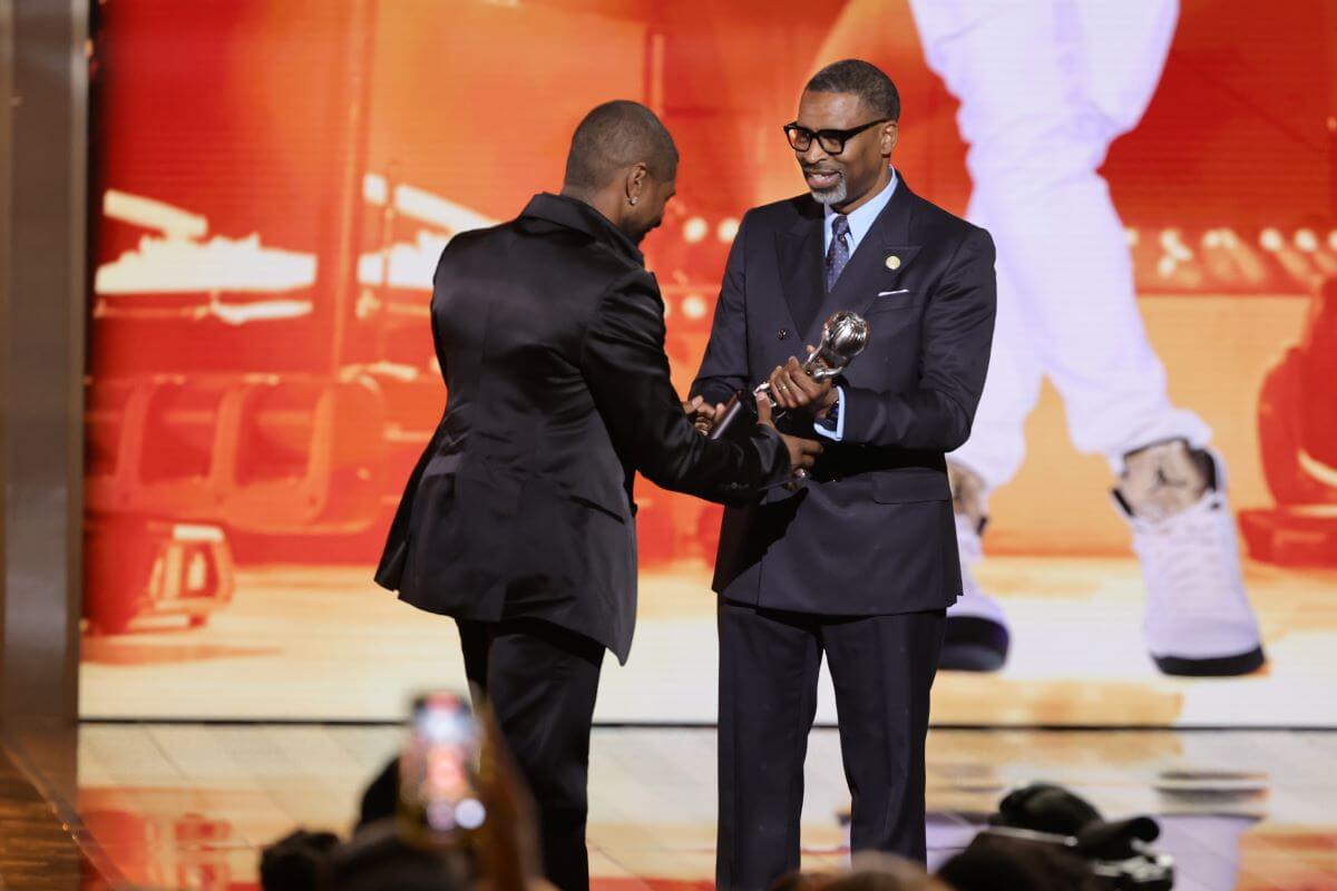 Usher accepts an award from NAACP President and CEO Derrick Johnson.