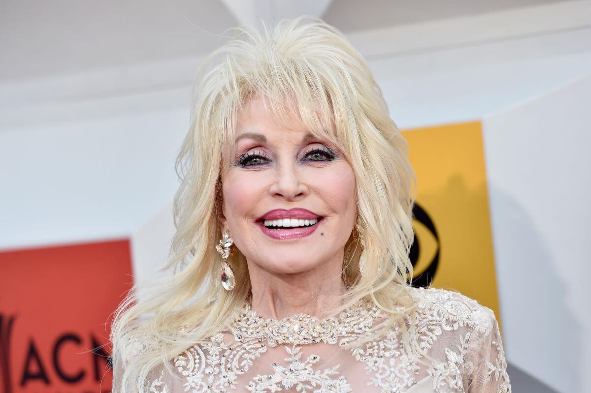 Dolly Parton wears a white lace top.