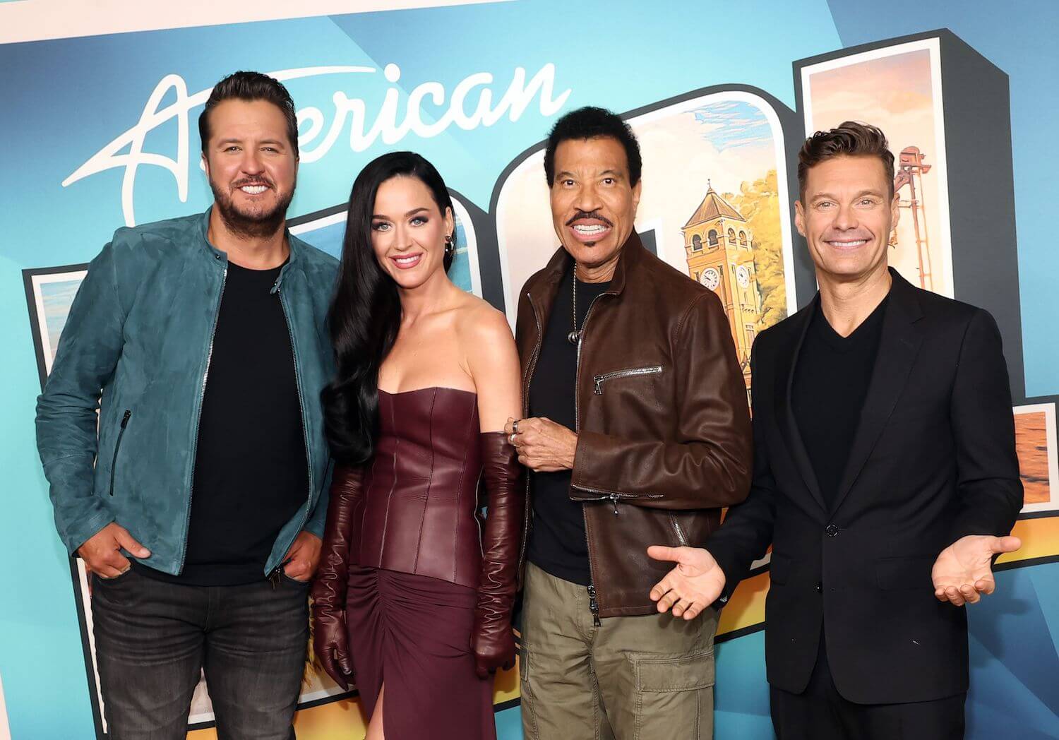 'American Idol' Season 22 host Ryan Seacrest standing next to Luke Bryan, Katy Perry, and Lionel Richie against an 'American Idol' backdrop