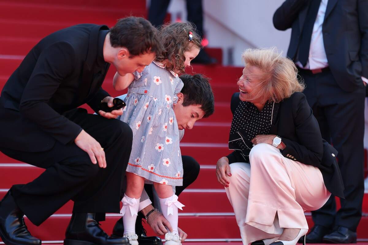Irish actor Barry Keoghan fixes Jackie Mellor's shoe on the red carpet at the 77th edition of the Cannes Film Festival