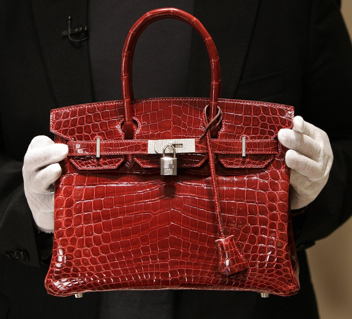 : A employee holds a 129,000 USD crocodile Hermes Birkin Bag for the press to see during a private opening for the new Hermes store