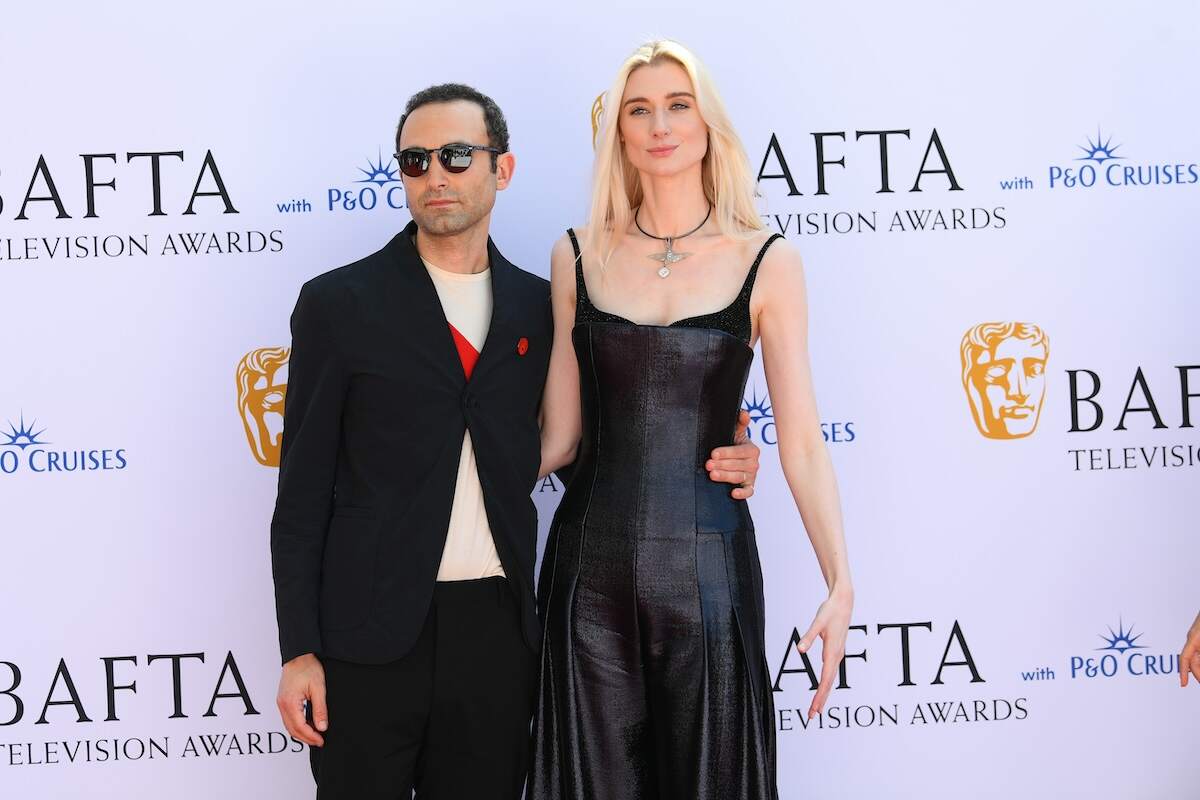 Actors Khalid Abdalla and Elizabeth Debicki stand together on the 2024 BAFTA red carpet while wearing black outfits