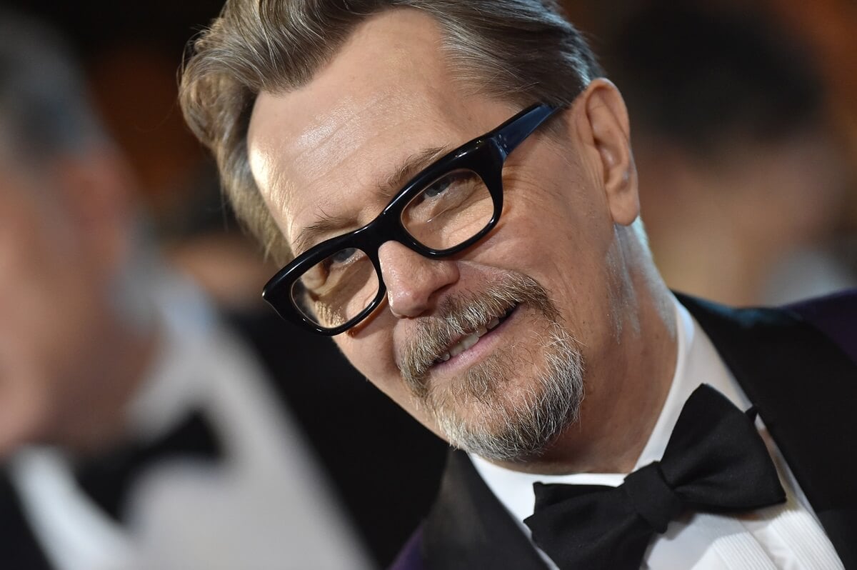 Gary Oldman posing in a suit at the 29th Annual Palm Springs International Film Festival Awards Gala.