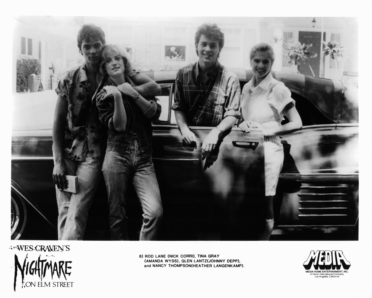 Nick Corri, Amanda Wyss, Johnny Depp, and Heather Langenkamp posing beside car in a scene from the film 'A Nightmare On Elm Street'.