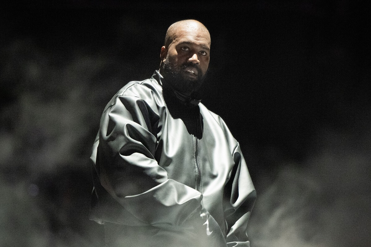 Kanye West performing on stage while wearing a baggy outfit.