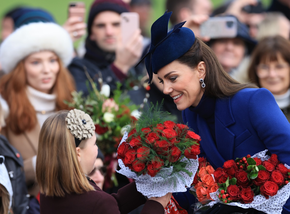 Kate Middleton gives Mia Tindall a bouquet as they greet well-wishers on Christmas