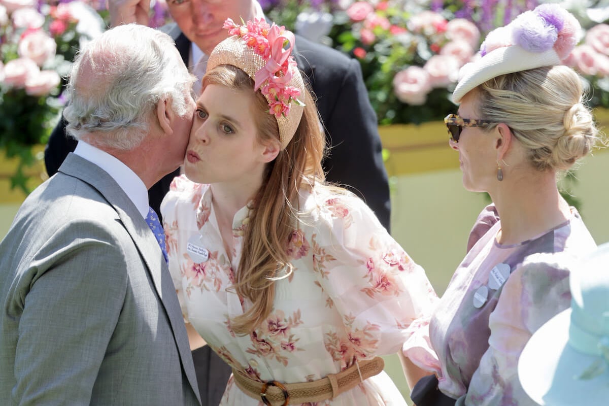 King Charles III, who wants Princess Beatrice to attend more royal family summer 2024 events, kisses Princess Beatrice on the cheek while Zara Tindall looks on