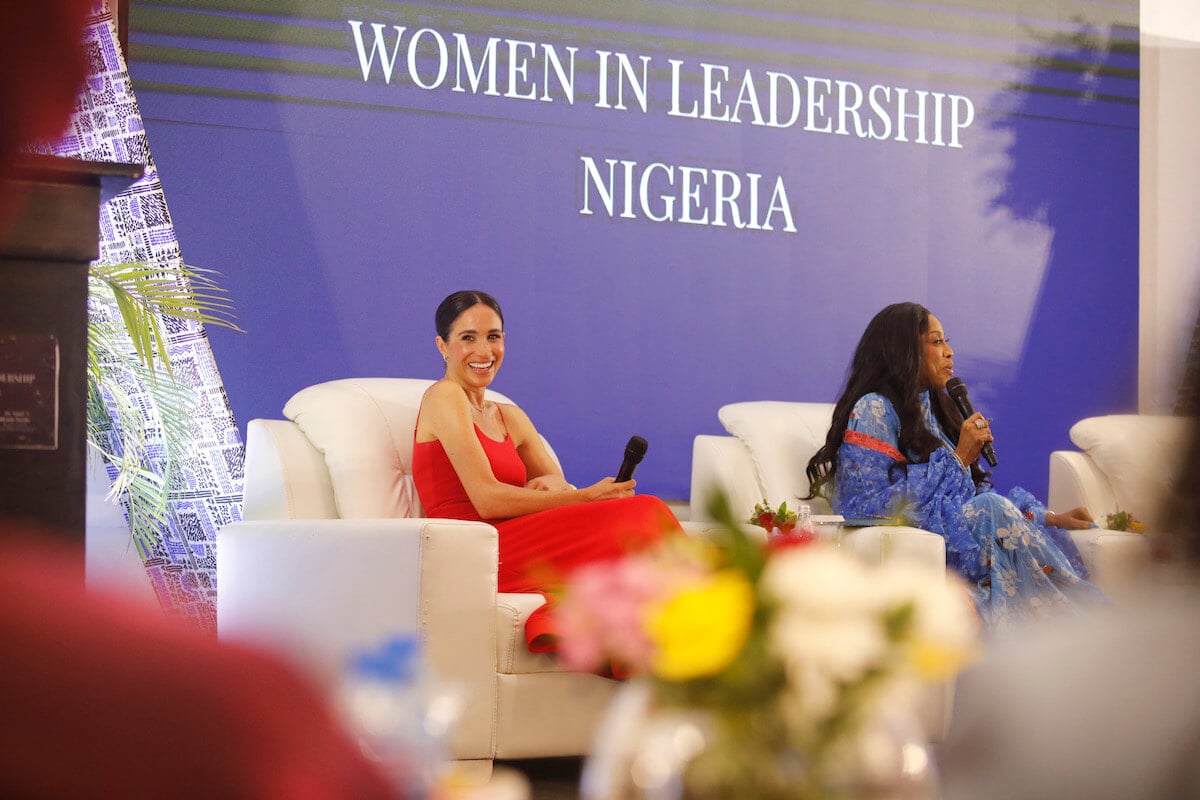 Meghan Markle, who revealed what Princess Lilibet told her during Nigeria visit, smiles as she sits in a chair holding a microphone
