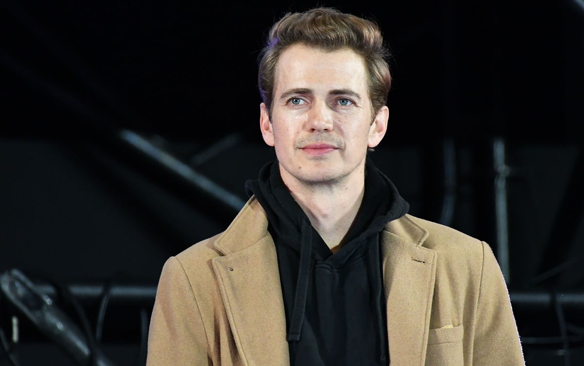 Hayden Christensen on stage wearing a brown jacket and black sweater at Tokyo Comic Con.