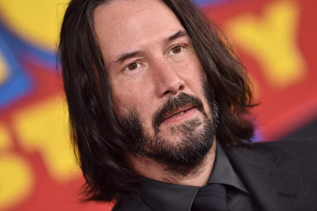 Keanu Reeves posing at the premiere of 'Toy Story 4' in a black suit.