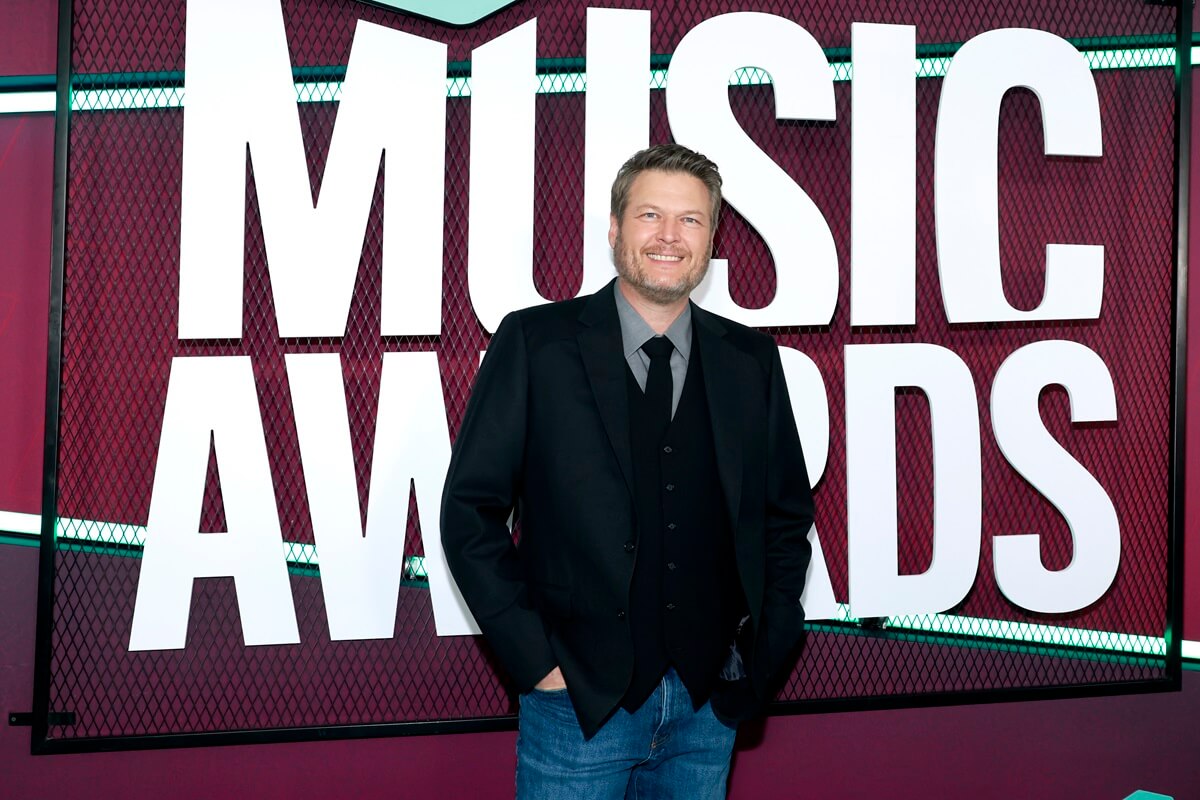 Blake Shelton posing in a suit and blue jeans at 2023 CMT Music Awards at Moody Center.