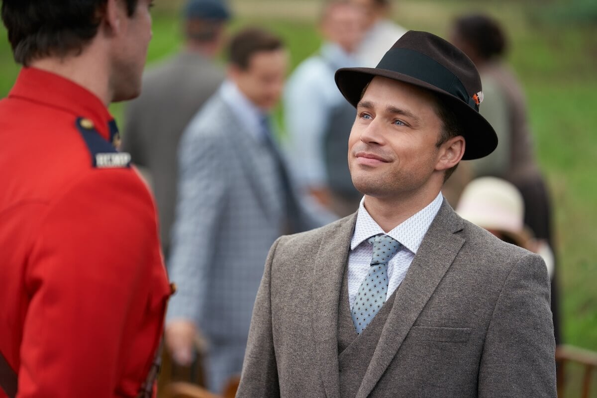 Tom Thornton, wearing a hat, looking at Nathan, in a red jacket and with his back to the camera in a scene from 'When Calls the Heart'