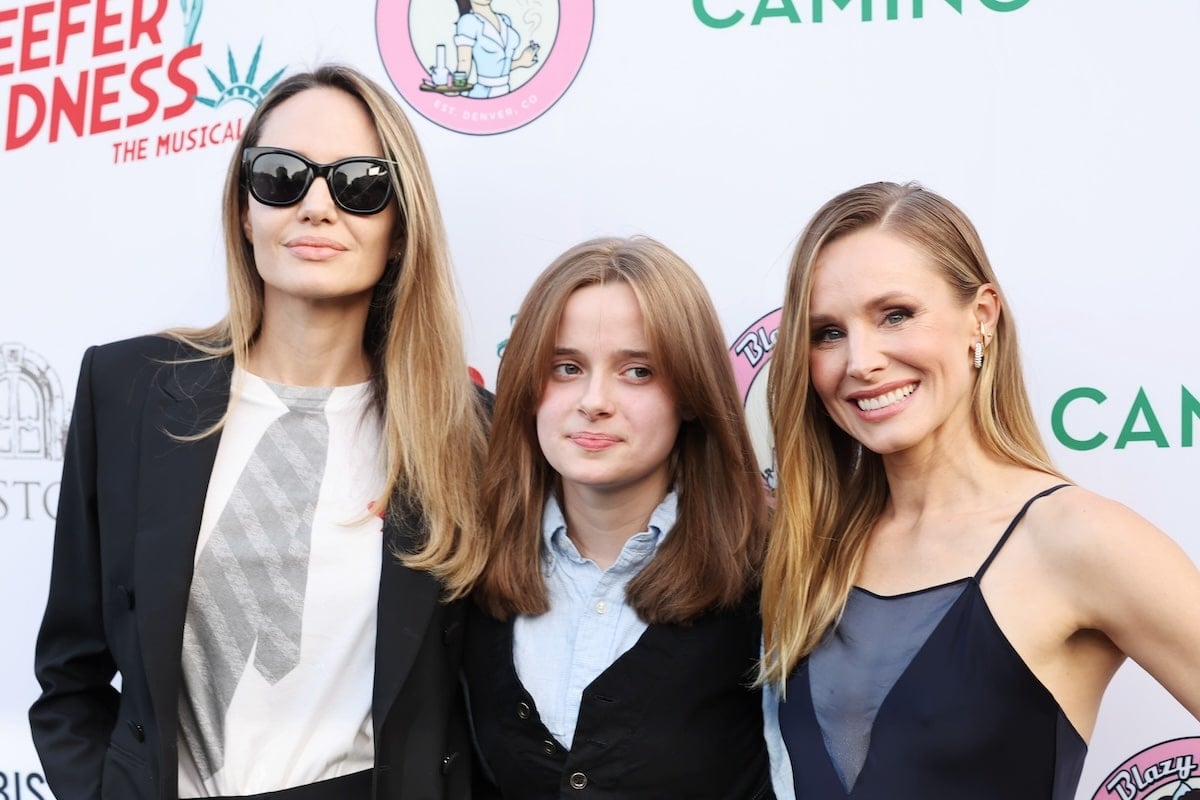 Celebrities Angelina Jolie, Vivienne Jolie-Pitt, and Kristen Bell stand together on the red carpet before the opening night of Reefer Madness