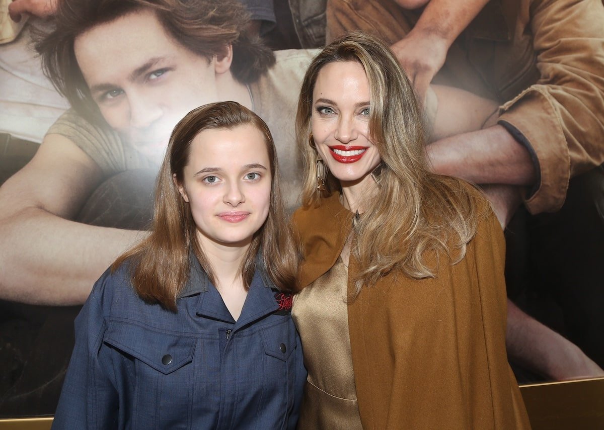 Angelina Jolie and Vivienne Jolie-Pitt stand together on the red carpet before attending The Outsiders