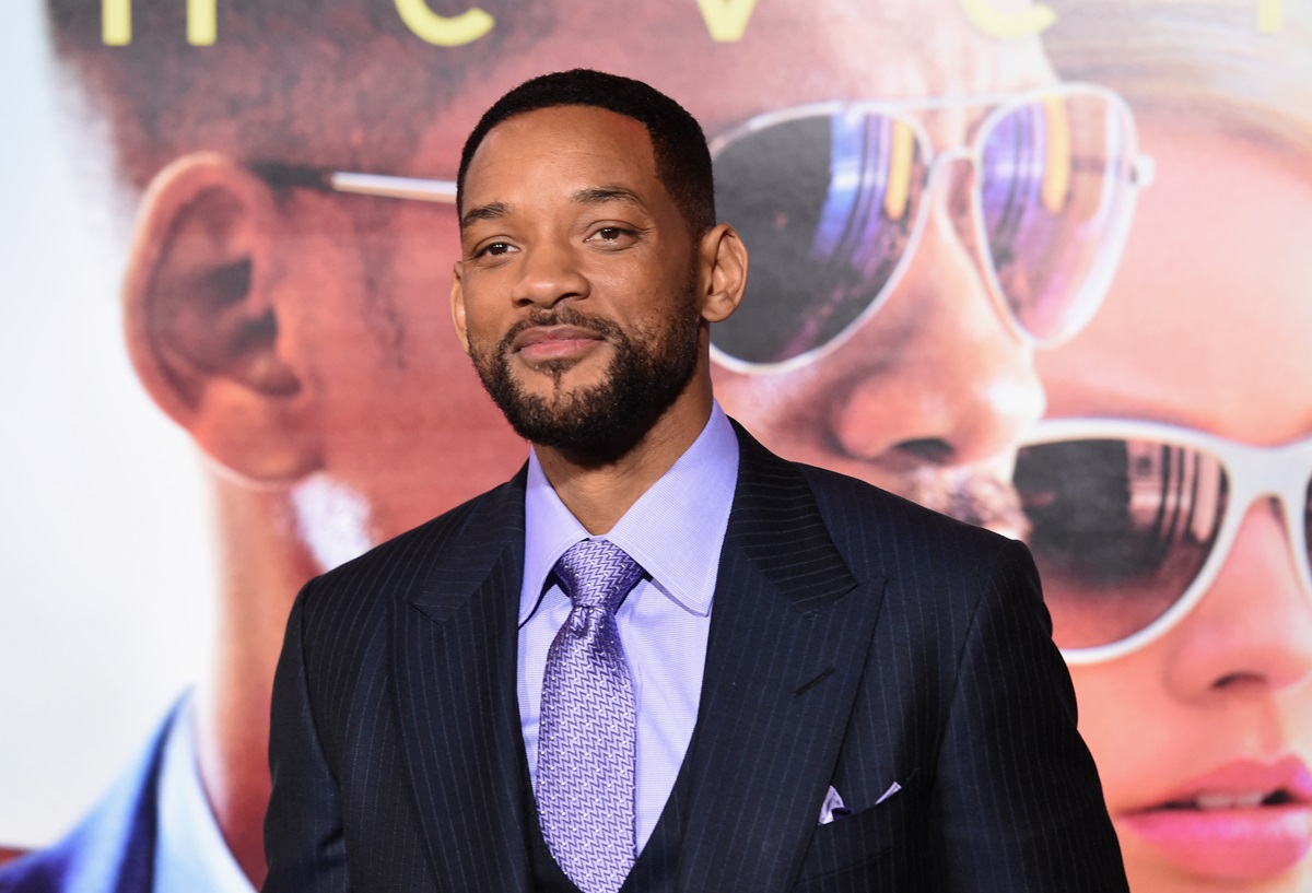 Will Smith posing in a black and purple suit at the premiere of 'Focus'.