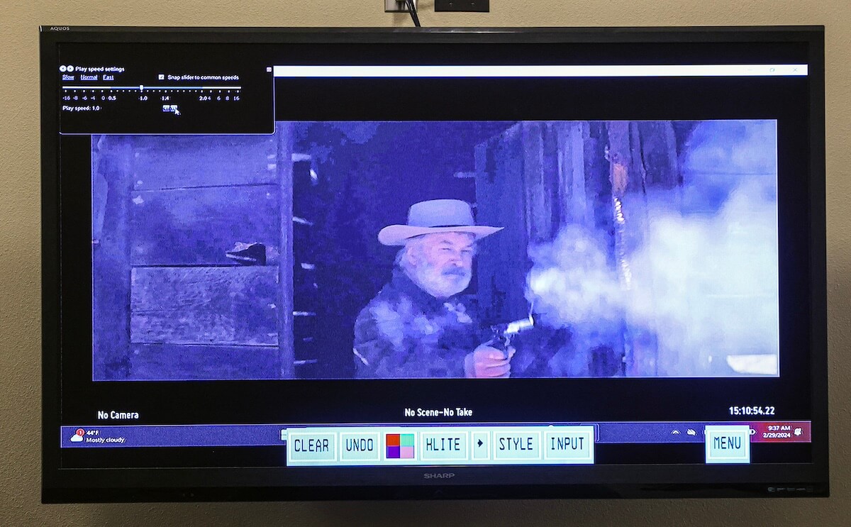 Image of a screen showing Alec Baldwin shooting a gun in the film 'Rust'