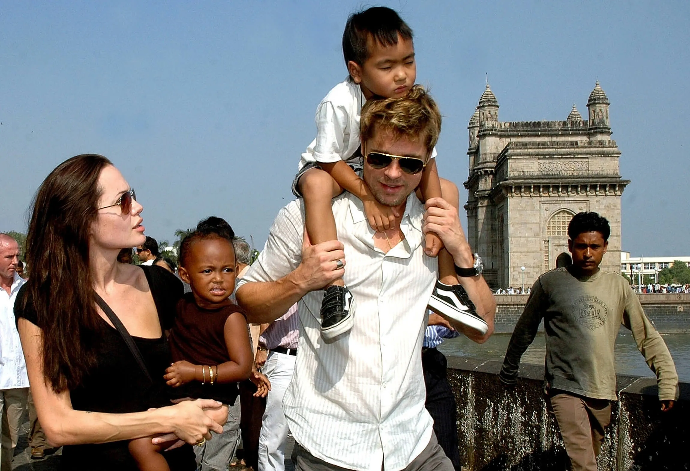 Angelina Jolie (L) holds daughter Zahara as husband and actor Brad Pitt (C) carries son Maddox during a stroll on the seafront promenade at the historic Gateway of India in 2006