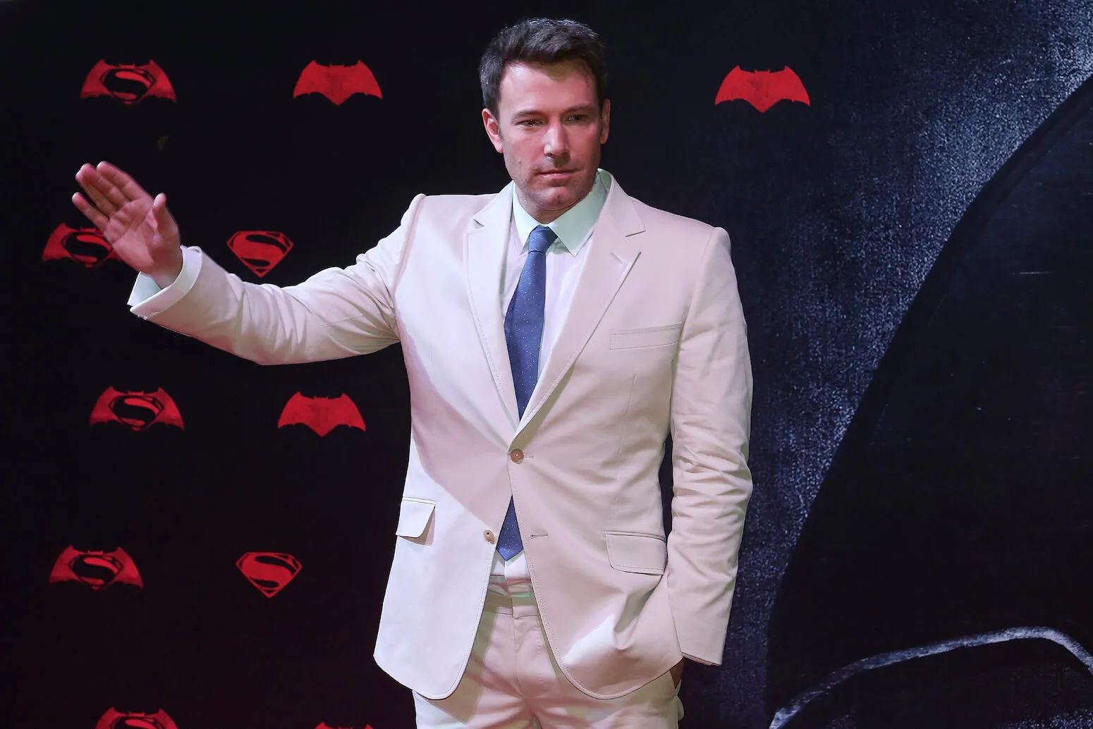 Ben Affleck waving in a beige suit at the 'Batman v Superman' premiere