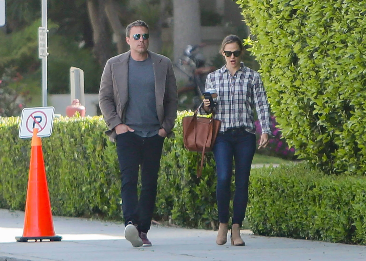 Ben Affleck and Jennifer Garner walking on a side walk in Los Angeles in 2019. They're dressed casually and wearing sunglasses. 