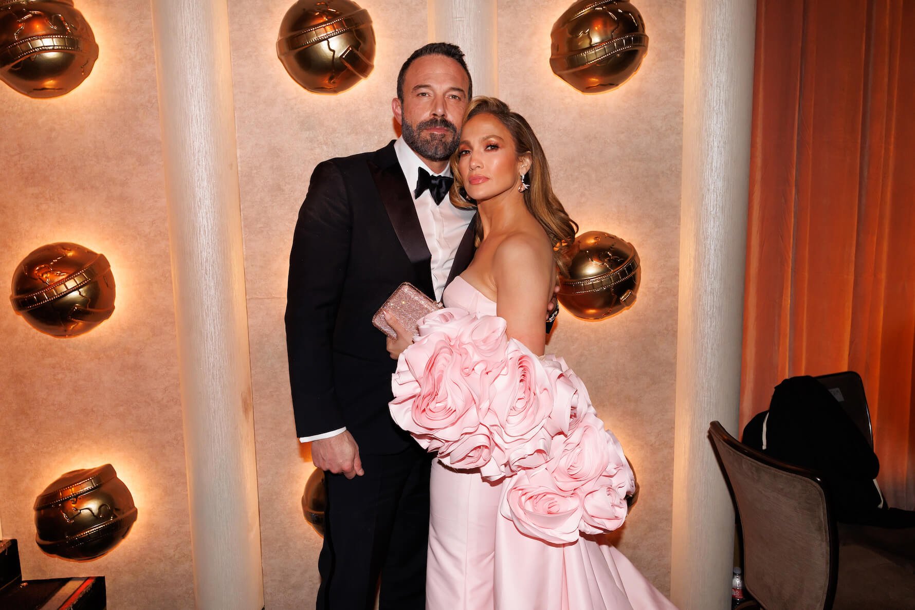 Ben Affleck in a suit and Jennifer Lopez in a pink dress posing together at the 81st Golden Globe Awards