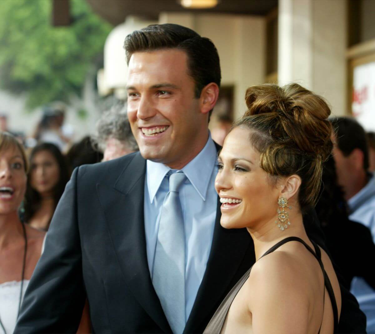 Ben Affleck and Jennifer Lopez stand on a red carpet together.