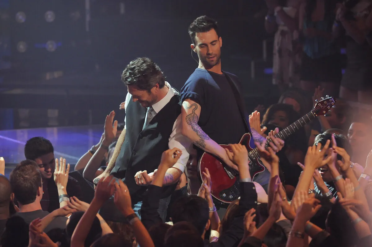 Blake Shelton and Adam Levine The Voice playing guitar while surrounded by a crowd on 'The Voice'