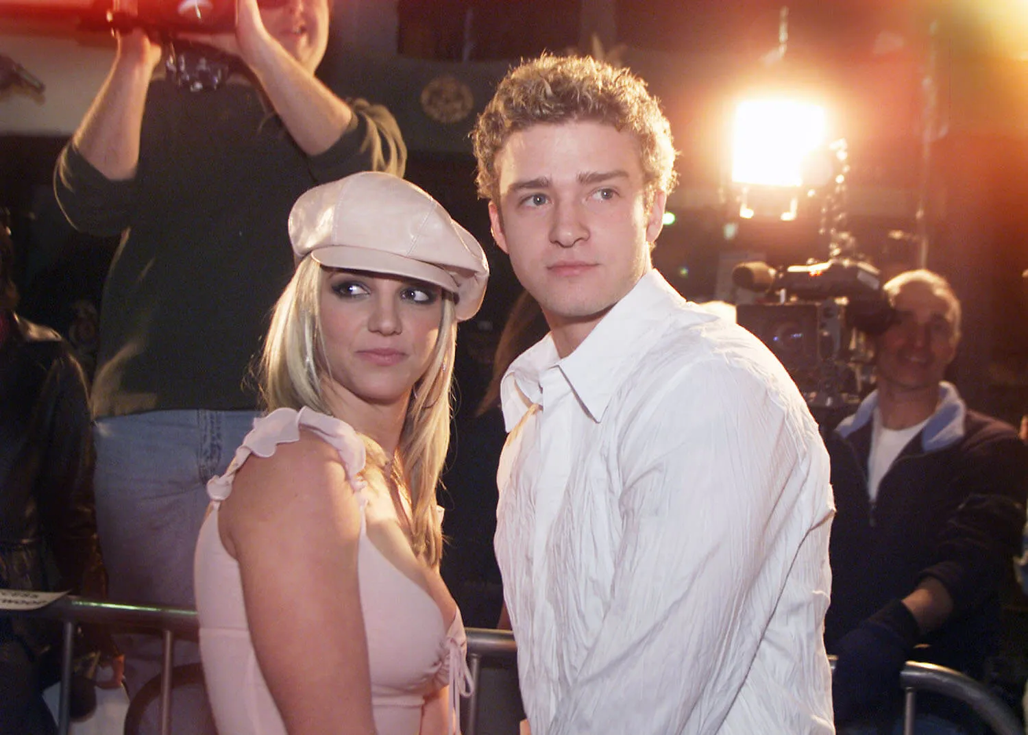 Britney Spears and Justin Timberlake holding hands and looking over their shoulders at the 'Crossroads' premiere in 2002