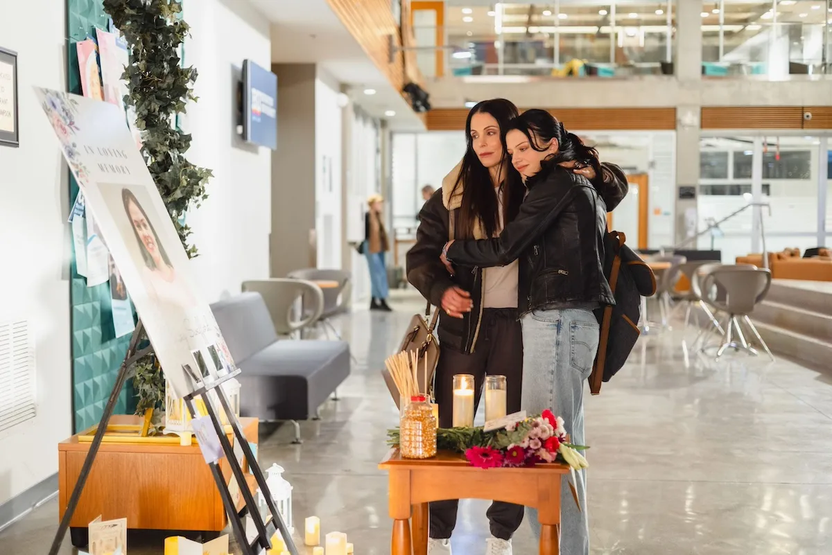 Bethenny Frankel and Clara Alexandrova looking at a poster on a stand in Lifetime's 'Danger in the Dorm'